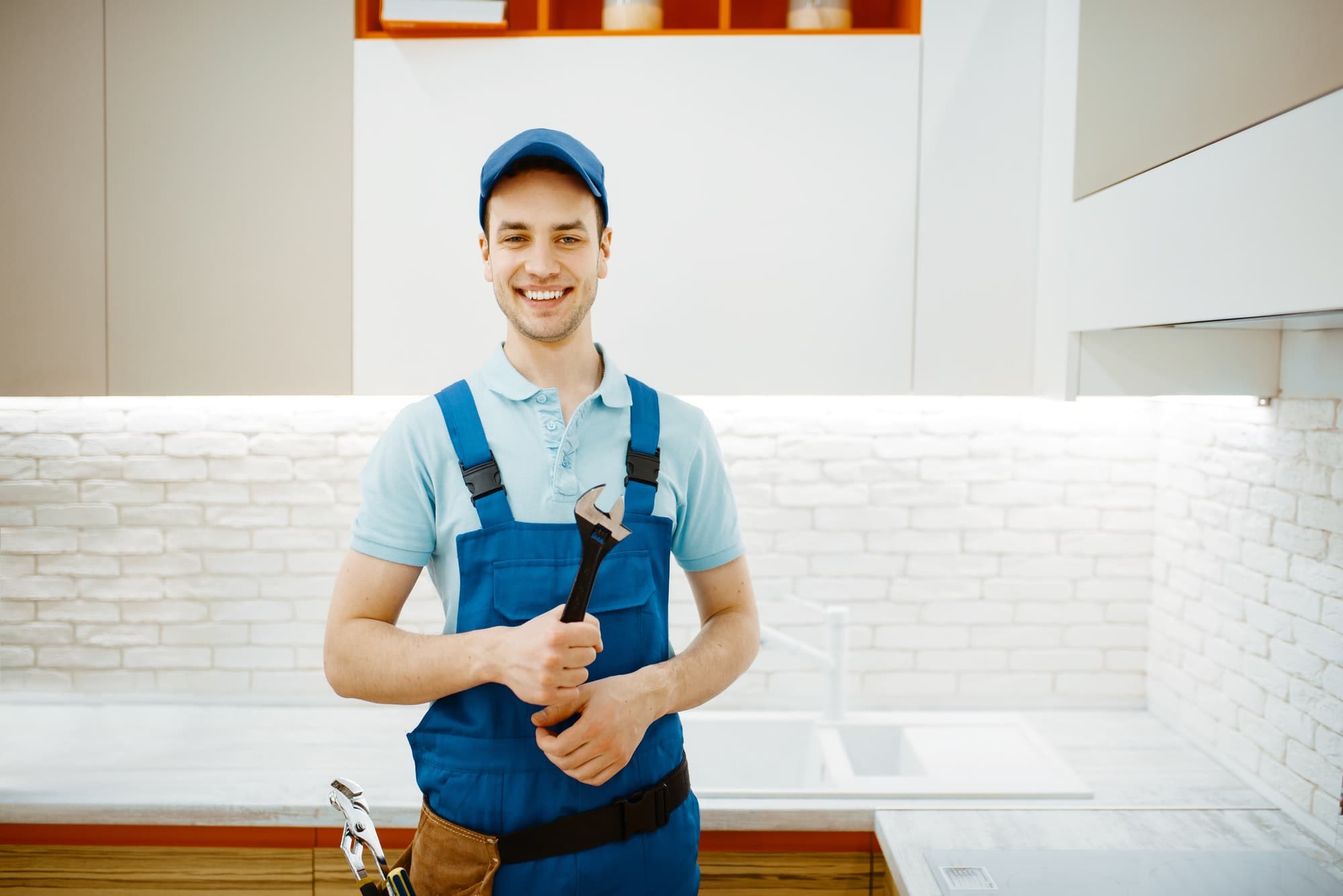 Plumber repairing a kitchen faucet